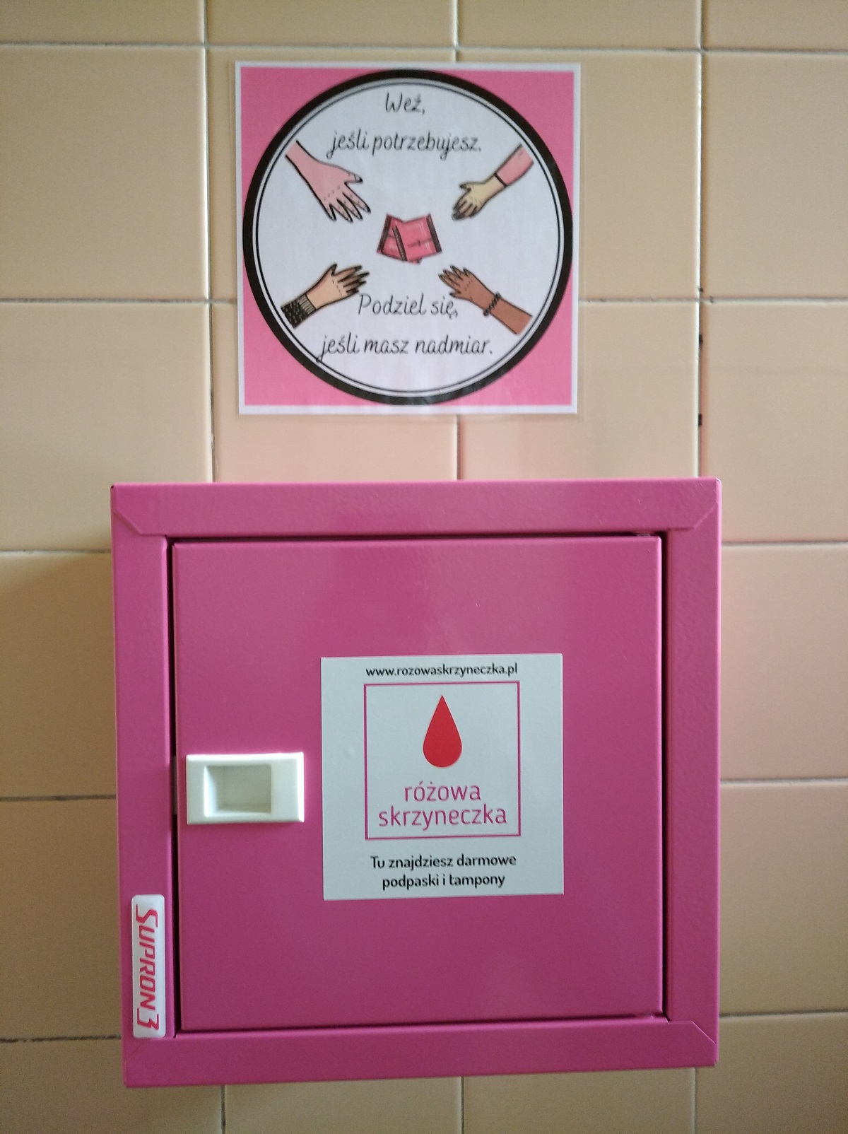 Różowa skrzynka z środkami higienicznymi dla kobiet powieszona na ścianie toalety