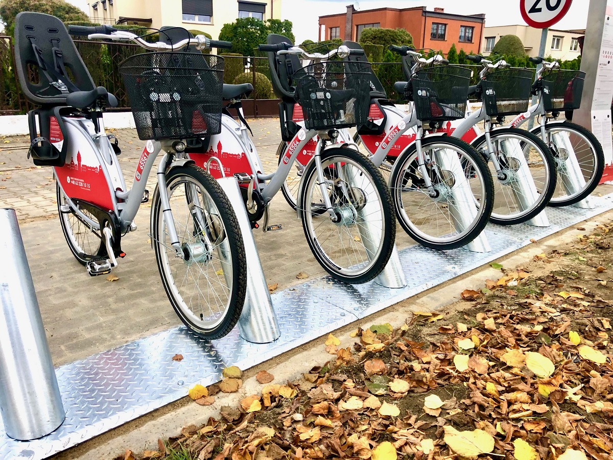 Pięć rowerów miejskich stojących w stojakach