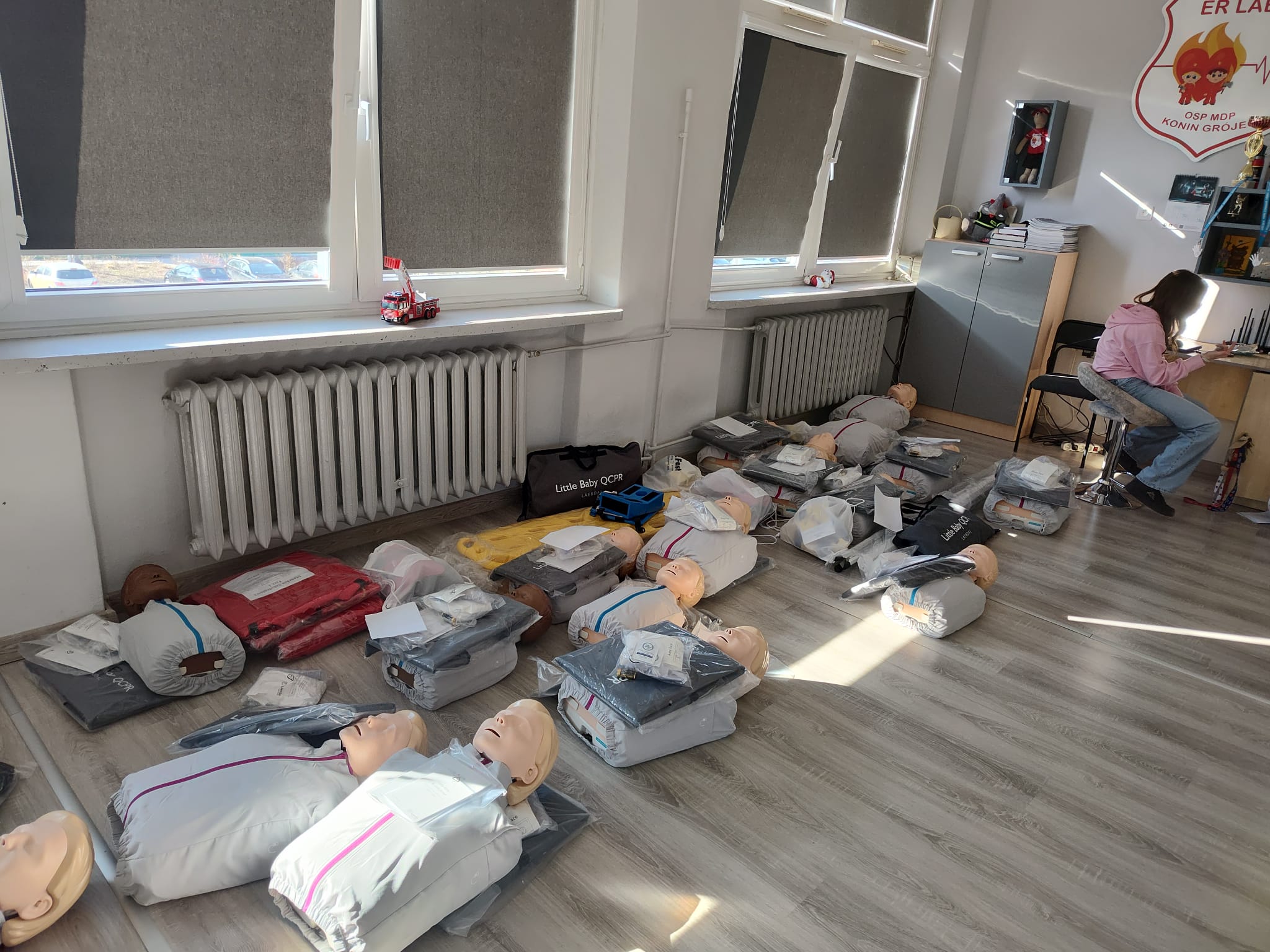 Sprzęt do ćwiczeń ratownictwa medycznego leży na podłodze w sali szkoleń